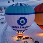 Hot air balloons over Cappadocia on a snowy day Nazar Balloons