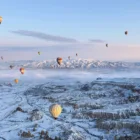 Hot air balloons over Cappadocia on a snowy day Nazar Balloons
