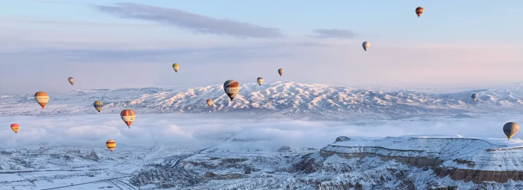 Hot air balloons over Cappadocia on a snowy day