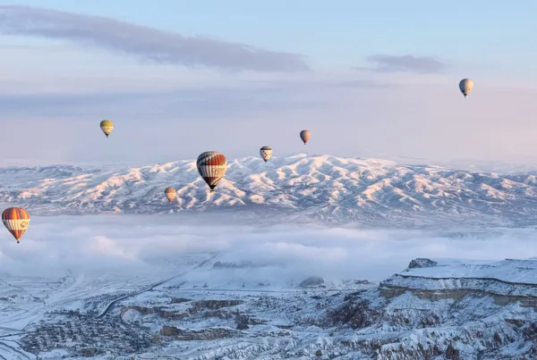 Hot air balloons over Cappadocia on a snowy day