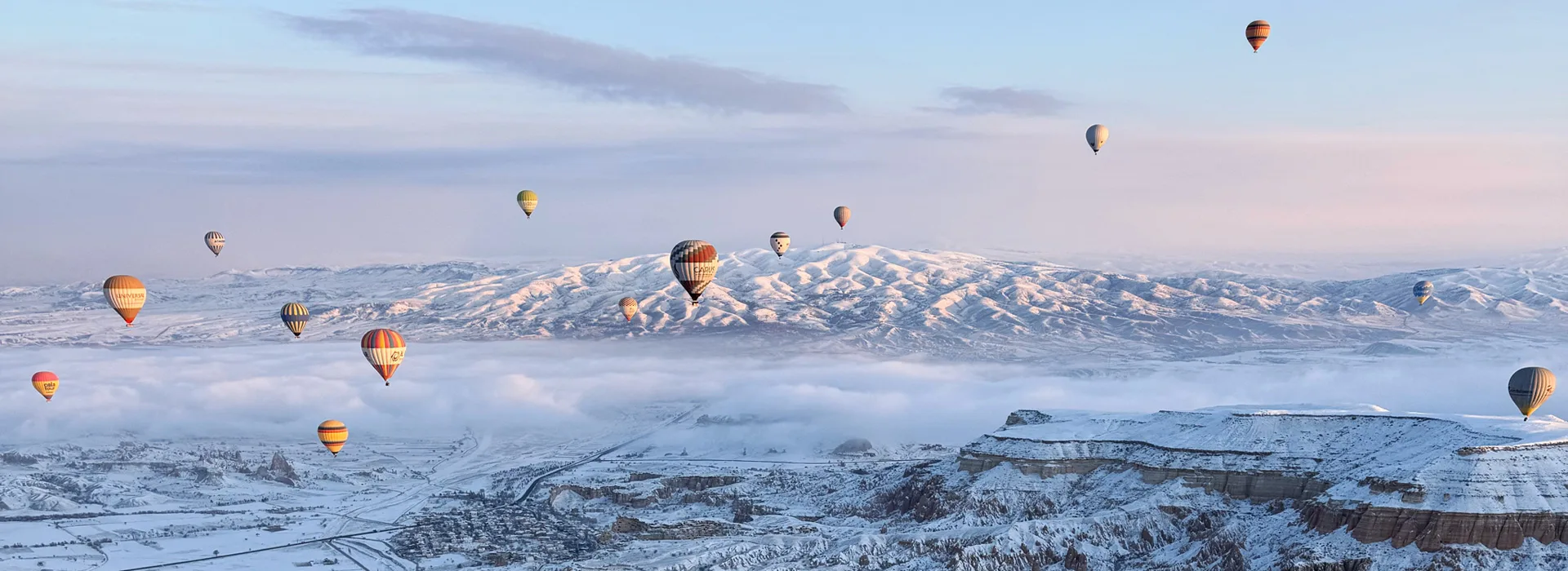 Hot air balloons over Cappadocia on a snowy day